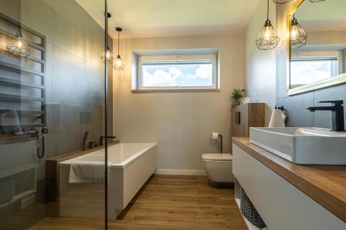 a bathroom with a tub and a sink and a toilet at Lamelove Apartments - Energylandia, Zator in Chocznia