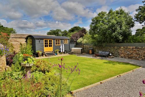 einen Garten mit einem winzigen Haus im Hintergrund in der Unterkunft FLORA Luxury Retreat, Private Garden, Views & Hot Tub in Durham