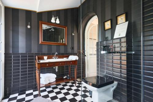 a black and white bathroom with a sink and a toilet at Bastide Les Cigales in Antibes