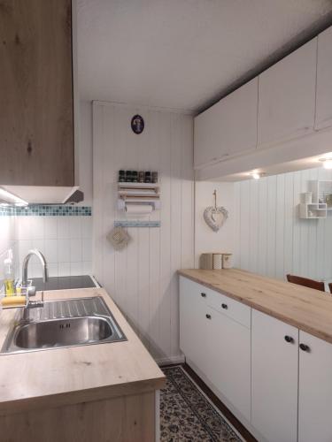 una cocina con armarios blancos y fregadero en Apartment Lilija en Bovec