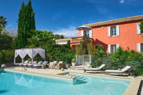 une maison avec une piscine devant une maison dans l'établissement Bastide Les Cigales, à Antibes