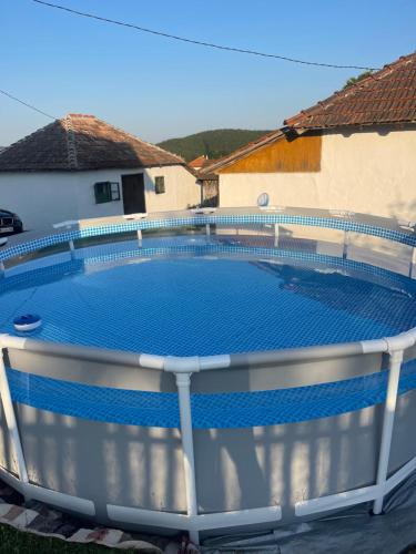 una gran piscina azul con una valla alrededor en Dedina kuća en Gornji Milanovac