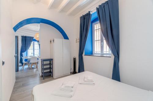 una camera con tende blu e un letto in una stanza di Rapallo Seaside Dream! Lovely Studio a Rapallo
