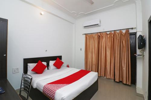 a bedroom with a large bed with red pillows at OYO Flagship 24199 Hotel Mid Town Ojus Tower in Rudrapur