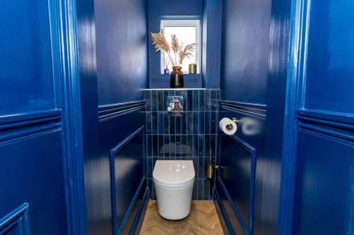Baño azul con aseo y pared azul en Luxury Accommodation In The City Centre With Free Parking, en Bournemouth