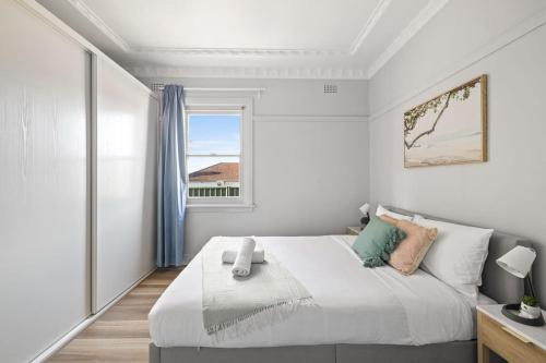 a white bedroom with a large bed and a window at Comfort Queen Room - Private - Prime Spot in Sydney
