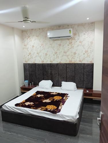 a bedroom with a bed with a black headboard at OYO Hotel Orvin In in Jabalpur