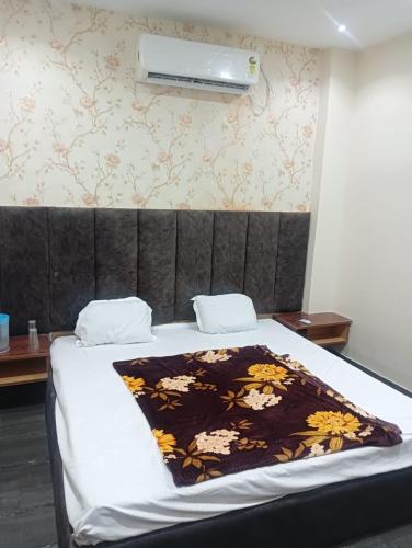 a bedroom with a bed with a blanket on it at OYO Hotel Orvin In in Jabalpur