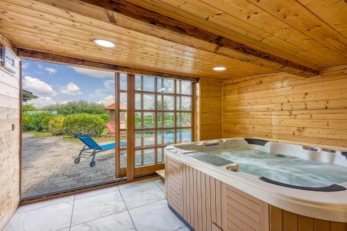 Cette chambre dispose d'un bain à remous et d'une grande fenêtre. dans l'établissement Wellness House On The River Kupa - Happy Rentals, à Banska Selnica