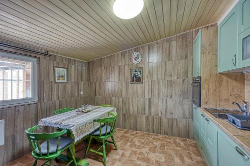 a kitchen with a table and green chairs at Wellness House On The River Kupa - Happy Rentals in Banska Selnica