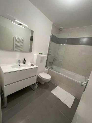 une salle de bain avec un lavabo, des toilettes et une douche dans l'établissement Villa avec Piscine privée proche mer, à La Garonnette-Plage