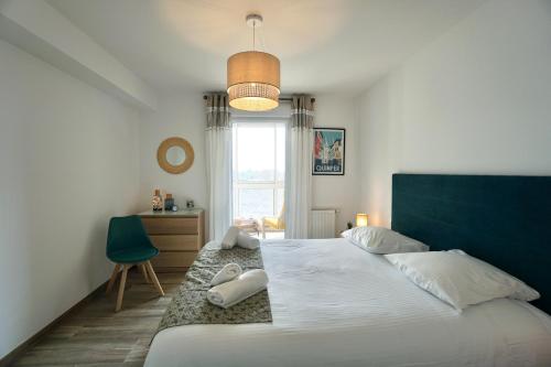 a bedroom with a large bed and a window at L'Escale in La Forêt-Fouesnant