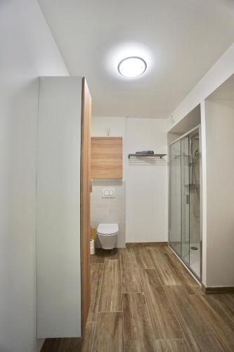 La salle de bains est pourvue de toilettes et d'une porte en verre. dans l'établissement L'Escale, à La Forêt-Fouesnant