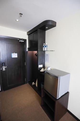 a room with a kitchen with a counter and a door at Paradise Spa Hotel in Port Dickson