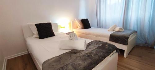 2 łóżka w małym pokoju z niebieskimi zasłonami w obiekcie Maison Carcari w mieście Pau