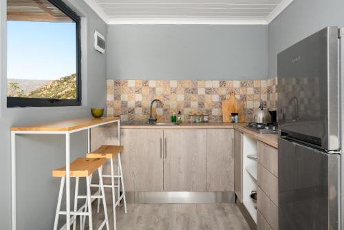 a kitchen with wooden cabinets and a window at Rocklands Eco Retreat - Adults Only in Cederberg
