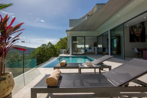 a villa with a swimming pool and a house at Zog Villas in Koh Samui 