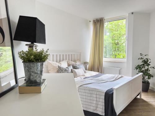 a white bedroom with a bed and a window at homebydoni - zentral I Parkplatz I Küche I Balkon in Bielefeld