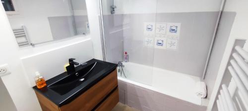 W łazience znajduje się czarna umywalka i prysznic. w obiekcie Maison Carcari w mieście Pau