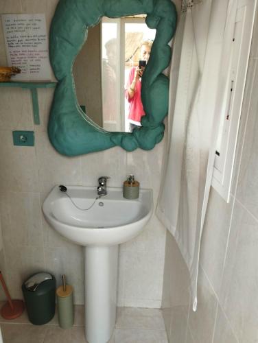 a woman taking a picture of a sink in a bathroom at Acoran Family Ocean View Guest House With Daily Yoga Practice Included North Gran Canaria PRIVATE ROOM PET FRIENDLY in Firgas