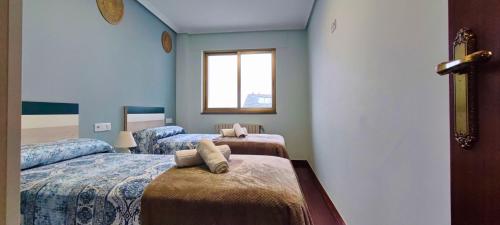 a room with two beds and a window at Casa-Nova Centro in Sarria