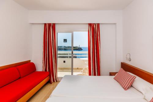 a bedroom with a bed and a red couch at Bellevue Belsana in Portocolom