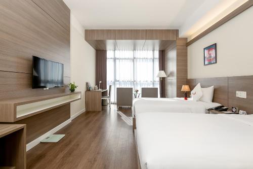 a hotel room with two beds and a flat screen tv at The Nalod Da Nang in Da Nang