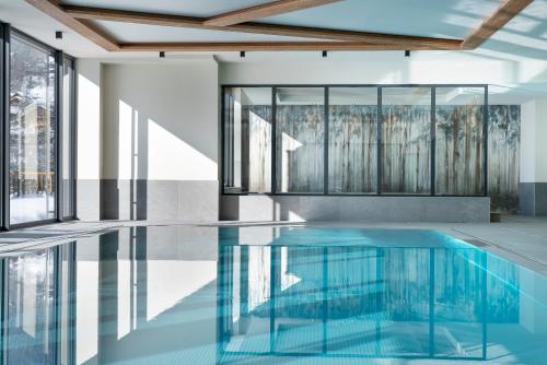 a swimming pool with glass walls and a ceiling at Les Chalets de Joy in Le Grand-Bornand