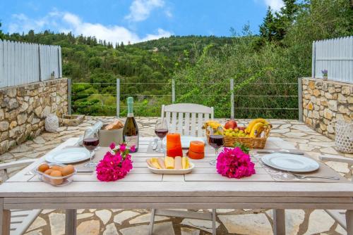a picnic table with a bunch of food and wine at Bask in the Beauty of Paxoi - Kirki's Summer Retreats with Private Jacuzzis in Ieromónachos