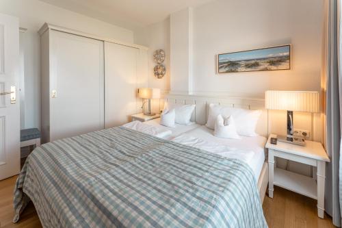 a hotel room with a large bed and a desk at Strandhotel Kurhaus Juist in Juist