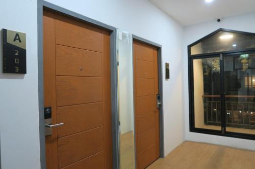a room with two wooden doors and a window at The Mira Hotel Chiang Rai in Chiang Rai