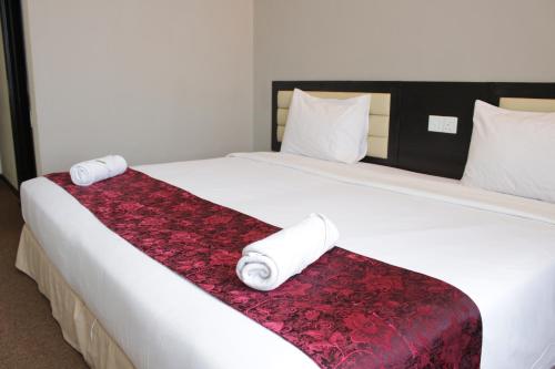 a bed with two rolls of toilet paper on it at Paradise Spa Hotel in Port Dickson