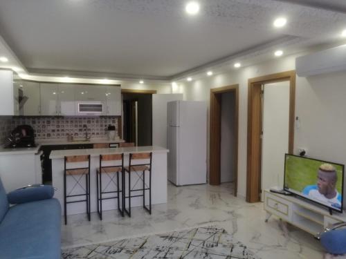 a living room with a kitchen and a tv in it at Deniz Apart in Demre