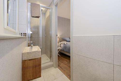 a bathroom with a sink and a bedroom with a bed at Apartment West in Whitby