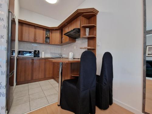 a kitchen with a table and black chairs at Apartament Słoneczny in Kołobrzeg