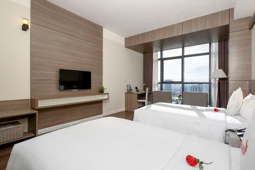 a hotel room with two beds and a flat screen tv at The Nalod Da Nang in Da Nang