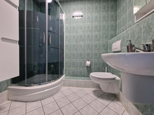 a bathroom with a shower and a toilet and a sink at Apartament Słoneczny in Kołobrzeg