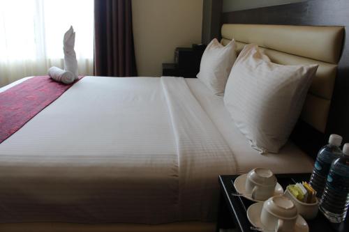 a bedroom with a large bed with white sheets and pillows at Paradise Spa Hotel in Port Dickson