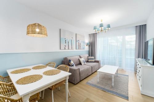 a living room with a couch and a table at FARO Apartamenty Polanki Aqua SPA Deluxe 4 baseny w cenie, Pools inklusive in Kołobrzeg