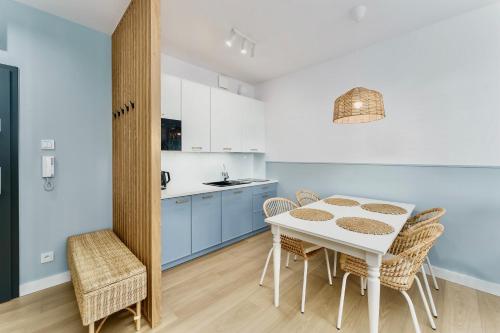 a kitchen and dining room with a table and chairs at FARO Apartamenty Polanki Aqua SPA Deluxe 4 baseny w cenie, Pools inklusive in Kołobrzeg