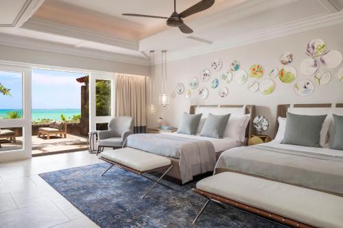 a bedroom with two beds and a living room at One&Only Le Saint Géran, Mauritius in Belle Mare
