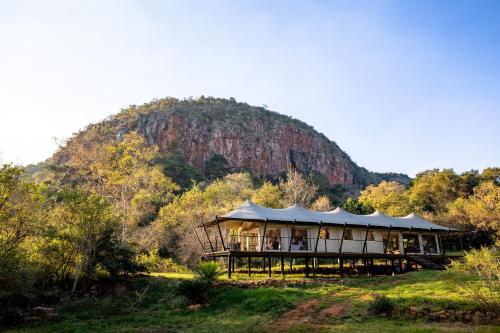 a large building with a mountain in the background at Mbizane Escarpment Retreat in Schoemanskloof