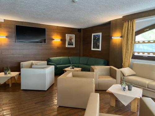 ein Wohnzimmer mit Sofas und einem Flachbild-TV in der Unterkunft Hotel Alle Tre Baite in Santa Caterina Valfurva