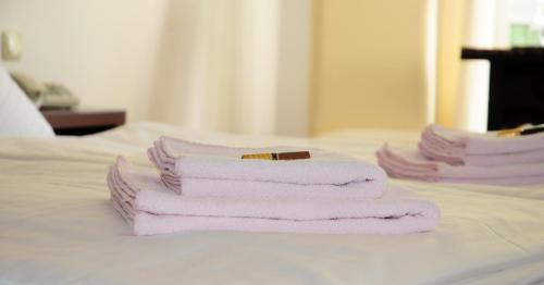 three towels stacked on top of a bed at Hotel Blankenese in Hamburg