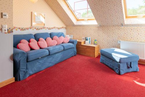 ein Wohnzimmer mit einem blauen Sofa und einem roten Teppich in der Unterkunft SaarlandTraum Weihermühle in Schmelz