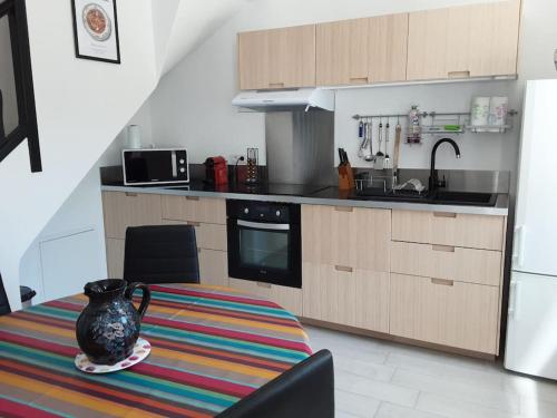 une cuisine avec un vase assis sur une table dans l'établissement Maison avec jardin, à Marseille