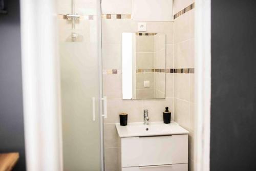 une salle de bain blanche avec un lavabo et une douche dans l'établissement STUDIO COSY VIEUX PORT, à Marseille