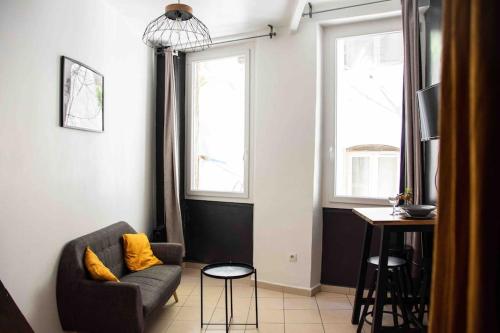 un salon avec un canapé et deux fenêtres dans l'établissement STUDIO COSY VIEUX PORT, à Marseille