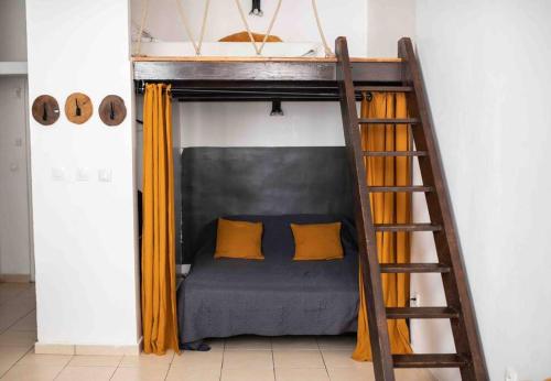 un lit superposé avec des rideaux jaunes et une échelle dans l'établissement STUDIO COSY VIEUX PORT, à Marseille