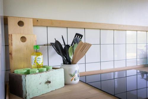 a kitchen counter with a container of utensils on a shelf at Norrby Residence,my vintage bnb 